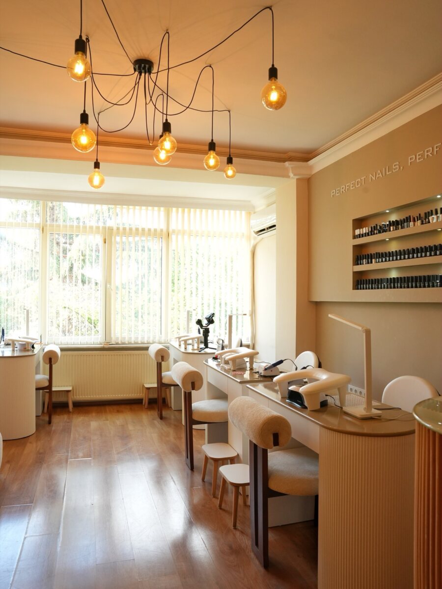 TüliNail Beauty Club manikür bölümü: nail bar, oje rafları ve sarkıt aydınlatmalar